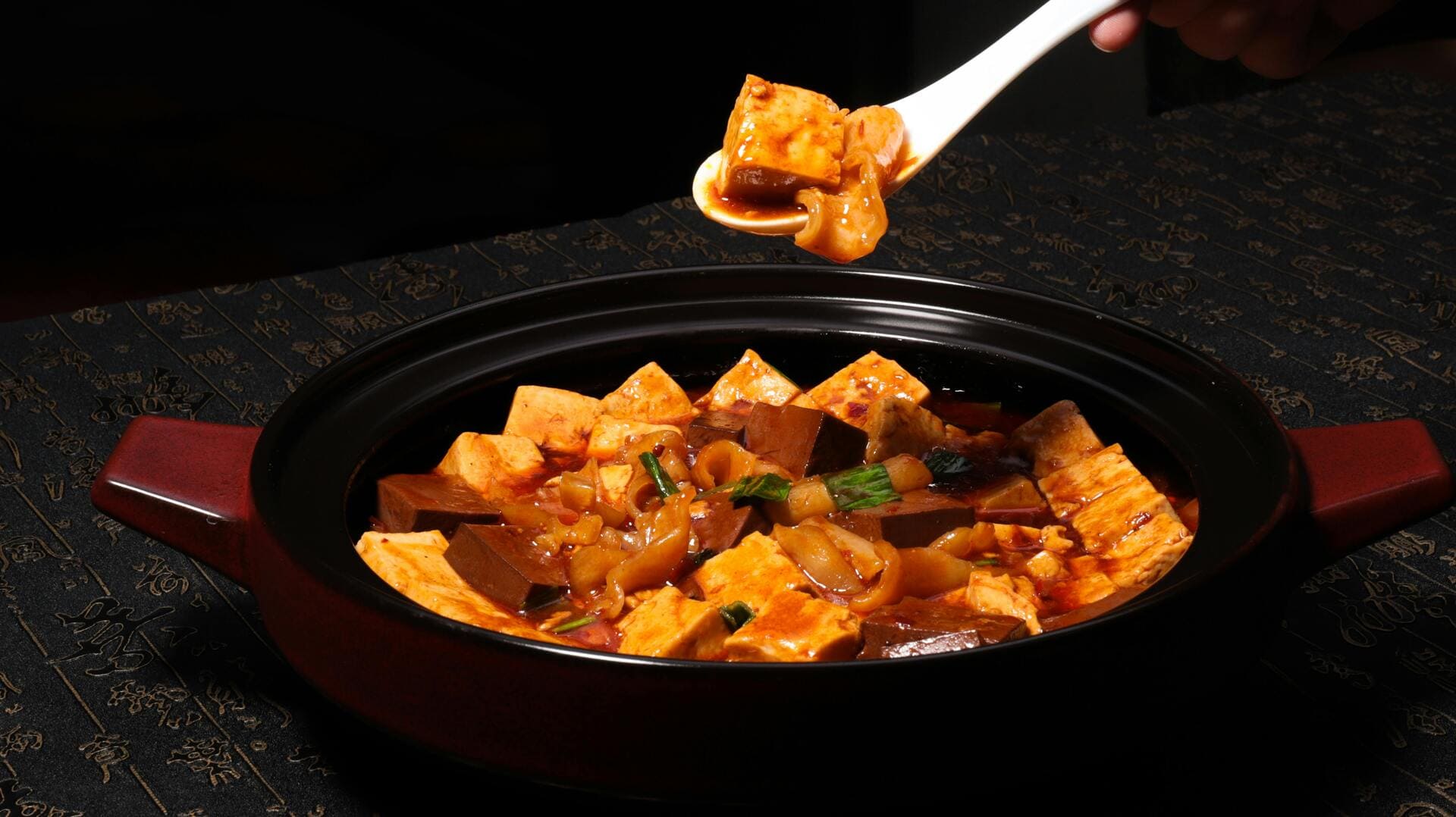 Mapo Tofu: Soft tofu in a fiery red sauce, topped with chopped green onions and Szechuan peppercorns
