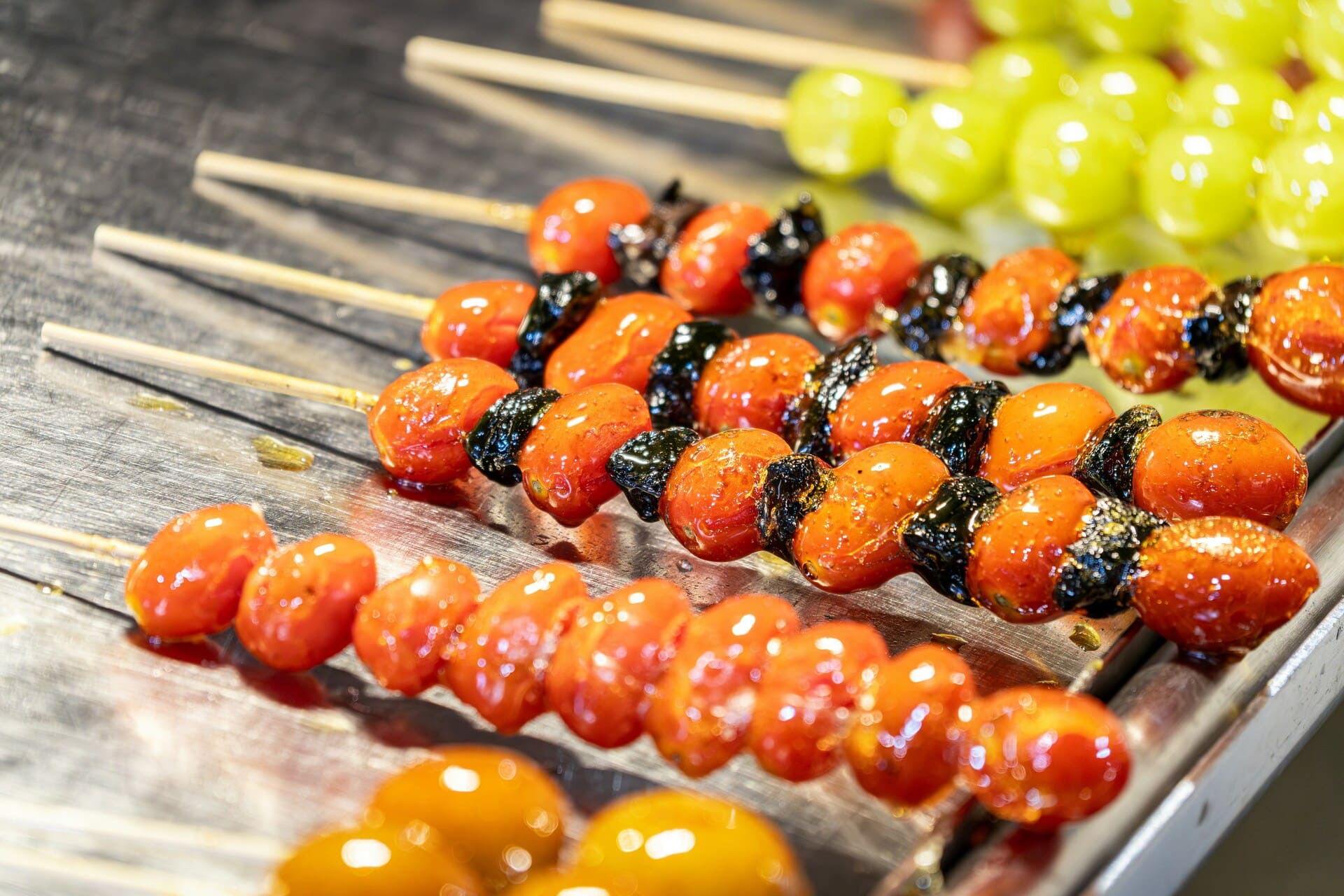 Tanghulu: Shiny red candied hawthorn berries on a stick, with a glossy sugar coating